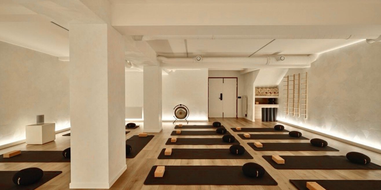 Salle lumineuse préparée pour une séance : tapis, coussins et gong